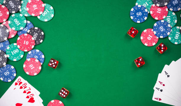 Casino games related items on green table, copy space.